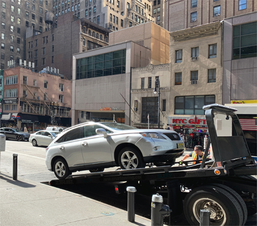 Car being towed in New York City