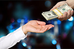handing over a bundle of banknotes from hand to hand