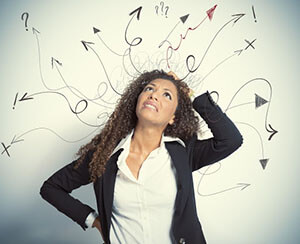 the woman wonders scratching her head, on the wall behind her painted arrows protruding from her head